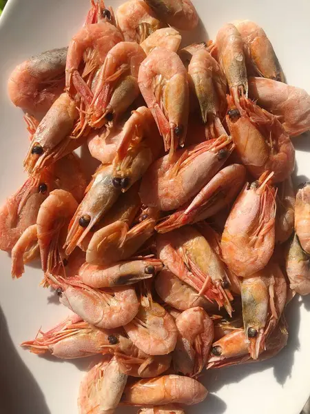 Beyaz bir tabak makroda pişmiş karides. 