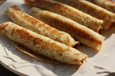 Beyaz tabakta etli leziz krep.