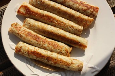 Beyaz tabakta etli leziz krep.