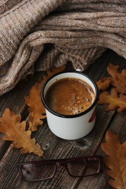 Amerikan kahvesi ve meşe yaprakları masanın üstünde.