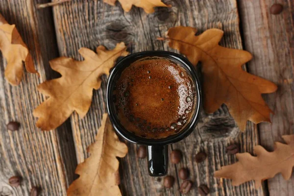 Espresso kahve ve meşe yaprakları masanın üstünde.