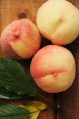 Masada yaprakları olan taze şeftaliler. 