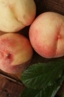 Masada yaprakları olan taze şeftaliler. 