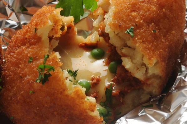 Açık arancino, pirinç ve bez dolguyu gösteriyor.