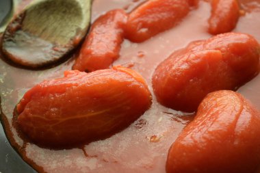 Tavada fesleğenli soyulmuş domates.