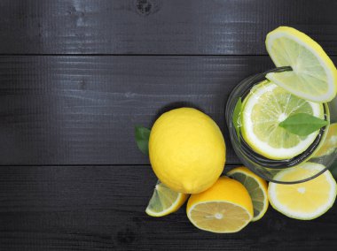 Küçük kase ve koyu ahşap zemin üzerine limon dilim taze limon suyu