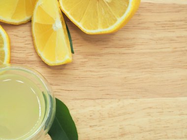 Küçük kase ve ahşap zemin üzerine limon dilim taze limon suyu