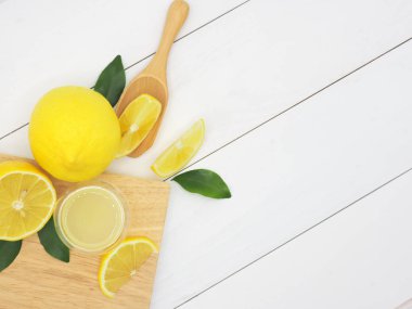 Bir küçük kase ve limon dilim Beyaz ahşap zemin üzerinde taze limon suyu