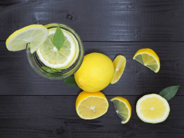 Küçük kase ve koyu ahşap zemin üzerine limon dilim taze limon suyu