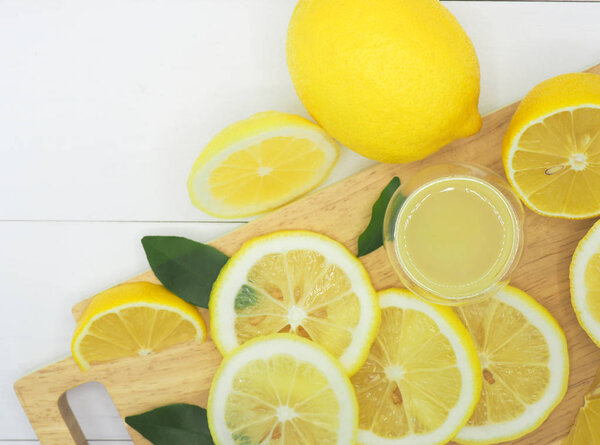 Свежий ломтик лимона с лимонадом на фоне белого дерева
