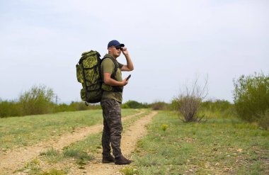 Bir gezgin bir sırt çantası ile yol boyunca yürüyüş