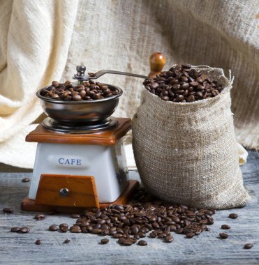 Bir kahve değirmeni yanında kahve çekirdekleri bir çantam