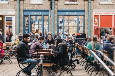Londra, İngiltere - 10 Mart 2018: Covent Garden Market, Londra, İngiltere'de en popüler turistik bir kafede açık masalarda oturan insanlar.