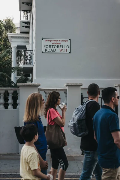 London, UK - July 21, 2018: People walking on Portobello Road, Notting Hill, London, past the street name sign. Portobello Road is the worlds largest antiques market with over 1,000 dealers. — Stock Image London July 2018 People Walking Portobello Road Notting Hill London Royalty Free Stock Images