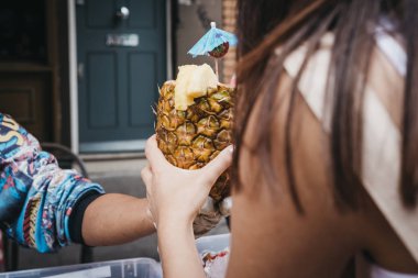 Taze ananas, Portobello Road Market, Londra, İngiltere'de bir pazar ahır içinde tropikal içki satın alma kadın hizmet.