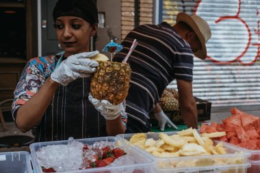 Londra, İngiltere - 21 Temmuz 2018: tropikal içki hazırlama kadın taze ananas, Portobello Road Market, Londra, İngiltere'de en popüler turistik bir piyasa ahır içinde görev yaptı.