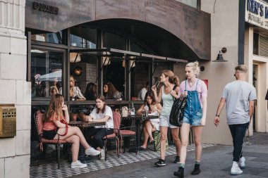 Londra, İngiltere - 22 Temmuz 2018: Diner Portobello Road Market, Londra, İngiltere'de en popüler turistik yerleri açık masalarda oturan insanlar.