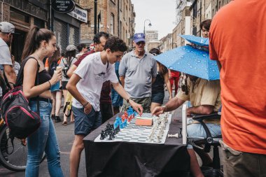 Londra, İngiltere - 22 Temmuz 2018: adam satranç ile yoldan geçenler tarafından Brick Lane, Londra'da. Sokakta Londra'nın Bangladeşli-Sylheti toplum kalbidir ve onun çok sayıda köri ev için ünlüdür.