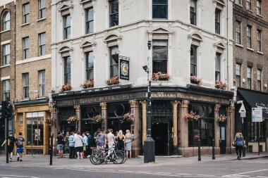 Londra, İngiltere - 22 Temmuz 2018: ayakta ve Shoreditch, East London, pub Jack iki kurban ile sözde dernek için ünlü Ten Bells'de barda dışında karın deşen içkiyi insanlar.