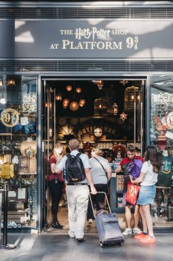 Londra, İngiltere - 26 Temmuz 2018: King's Cross istasyonuna, Londra, istasyonuna Hogwarts okul öğrencileri Hogwarts Express giden yer içinde peron 9 3/4 tarafından Harry Potter dükkanı giren insanlar.