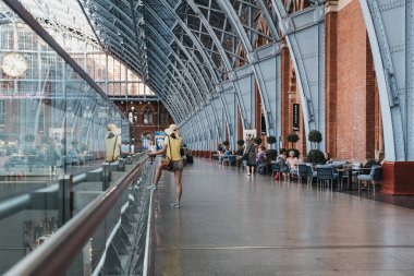 Londra, İngiltere - 26 Temmuz 2018: Sarı top St. Pancras İstasyonu içinde telefonda konuşurken bir kimliği belirsiz bir kadın. St. Pancras Londra ve Eurostar ana sayfa bulunan en büyük tren garları biridir.