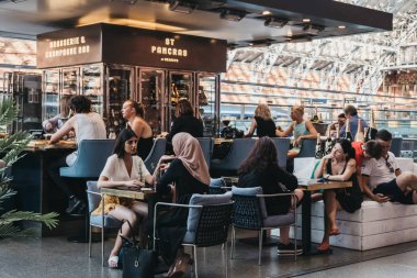 Londra, İngiltere - 26 Temmuz 2018: St. Pancras İstasyonu, Londra ve Eurostar ana sayfa bulunan en büyük tren garları içinde bir barda oturan insanlar.