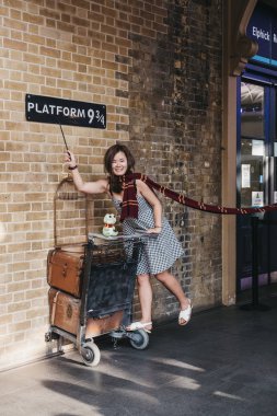 Londra, İngiltere - 26 Temmuz 2018: King's Cross istasyonuna, Londra, istasyonuna Hogwarts okul öğrencileri Hogwarts Express giden yer içinde peron 9 3/4 tarafından fotoğraf çekmek insanlar.
