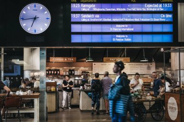 Londra, İngiltere - 26 Temmuz 2018: onların tren kalkış kurulu St. Pancras İstasyonu içinde altında bekleyen bir kafede oturan insanlar Londra ve Eurostar evine bir en büyük tren istasyonları.