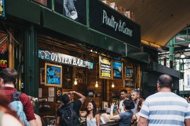 Londra, İngiltere - 24 Temmuz 2018: Satıcı ve müşteri semt pazarında bir istiridye barında, en büyük ve en eski gıda biri Londra'da pazarlar.