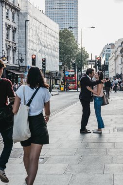 Londra, İngiltere - 24 Temmuz 2018: Oxford Street, London, kentin en ünlü caddelerinden biri yoldan geçenler tarafından önünde öpüşen insanlar.