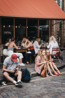 Londra, İngiltere - 22 Temmuz 2018: insanlar, Erza Caddesi üzerinde yere oturmuş, Columbia yol çiçek pazarı ziyaret ettikten sonra rahatlatıcı bir semt pazarı Doğu Londra'daki her Pazar günü açık mı.