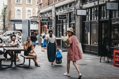Londra, İngiltere - 22 Temmuz 2018: Spitalfields pazarında, Londra Moda, antika ve gıda tezgahları ile en iyi hayatta kalan Victorian Pazar koridorlarda yürürken insanlar.