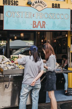 Londra, İngiltere - 21 Temmuz 2018: dış Mcmanus kardeşler istiridye ve Portobello Road Market, en popüler turistik Prosecco bar siteleri Londra, İngiltere'de duran insanlar.