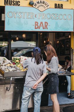 Londra, İngiltere - 21 Temmuz 2018: dış Mcmanus kardeşler istiridye ve Portobello Road Market, en popüler turistik Prosecco bar siteleri Londra, İngiltere'de duran insanlar.
