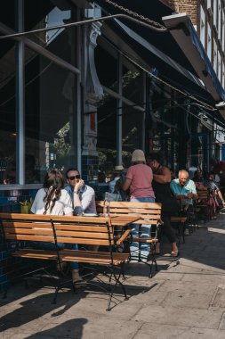 Londra, İngiltere - 21 Temmuz 2018: Portobello Road Market, Londra, İngiltere'de en popüler turistik bir restoranda açık masalarda oturan insanlar.