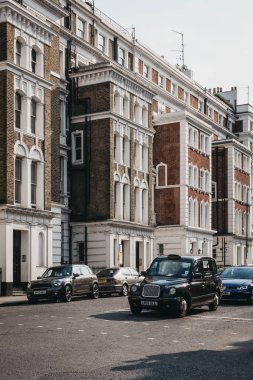 Londra, İngiltere - 21 Temmuz 2018: Siyah kabin bir yolda sonraki Notting Hill, Londra, bir yıllık karnaval için ünlü şehir en lüks alanlarında teraslı evler.