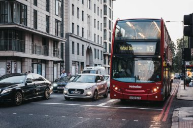 Londra, İngiltere - 26 Temmuz 2018: Otomobil ve bir kırmızı çift katlı otobüs sayısı 113 Oxford caddesine doğru Marylebone, Londra, İngiltere, bir sokakta alacakaranlıkta. Çift katlı otobüs kentin ikonik bir semboldür.