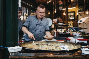 Londra, İngiltere - 17 Eylül 2018: satıcı, bir kısmını yeşil Tay Curry sokak gıda stand semt pazarında bir kase koyarak en büyük ve en eski gıda biri Londra'da pazarlar.