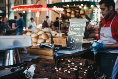 Londra, İngiltere - 17 Eylül 2018: Browni Borough Market, arka planda satıcı satış. Borough Market Londra'nın en büyük ve en eski gıda piyasaları biridir.