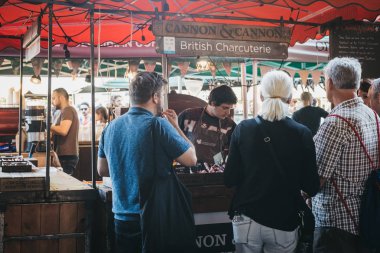 Londra, İngiltere - 24 Temmuz 2018: Satıcı ve müşteri charcuterie stand semt pazarında, en büyük ve en eski gıda biri Londra'da pazarlar.