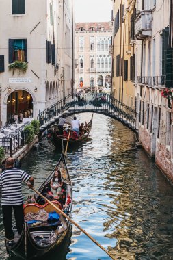 Venice, İtalya - 02 Temmuz 2017: Gondol Venedik, İtalya, dar bir kanal yaz aylarında turist. Tekneler ulaşım kentin ana modu vardır.