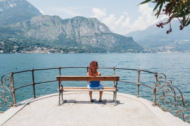 Bellagio, İtalya - 06 Temmuz 2017: Bellagio bir bankta rahatlatıcı, Como Gölü bakan kadın. Bellagio genellikle 