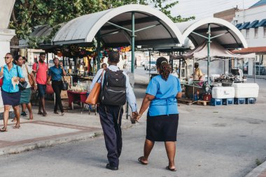 Bridgetown, Barbados - 26 Haziran 2018: Bridgetown, Barbados başkenti ve bir liman kenti sokak pazarında Adaları güneybatı kıyısında yürüyen bir çift tutuşup arka görünümü