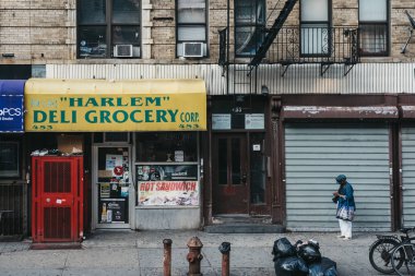 New York, ABD - 01 Haziran 2018: Kadın Harlem, Nyc Şarküteri yanındaki bir sokakta duruyor. 1920'lerden beri Harlem bir Binbaşı Afro-Amerikan Konut, kültür ve iş merkezi olarak bilinmektedir.