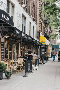 New York, Amerika Birleşik Devletleri - 29 Mayıs 2018: Garson Manhattan, New York şehrinin en yoğun nüfuslu borough restoranda açık masalarda oturan insanlar için yiyecek getiriyor.