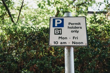 Bir sokakta konut Londra, İngiltere, yemyeşil bitki örtüsü karşı kısıtlamalar otopark ile bir işareti kapatmak.