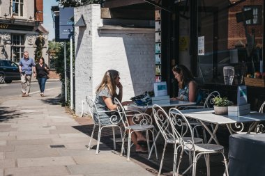 Londra, İngiltere - 1 Ağustos 2018: oturan ve Barnes, varlıklı bir yerleşim bölgesi olan Londra köy atmosferi için ünlü bir kafede açık bir masada sohbet kadın.