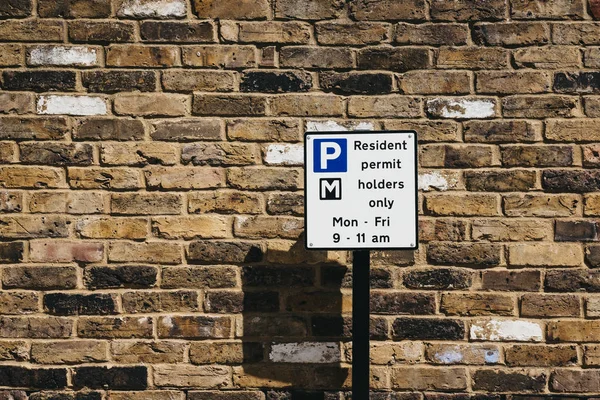 关闭一个标志与停车限制在一条住宅街道在伦敦 反对砖墙 — 图库照片