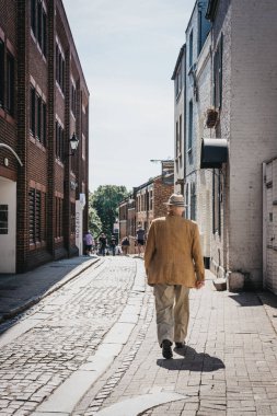 Londra, İngiltere - 1 Ağustos 2018. Richmond, Güney-Batı Londra çok sayıda park ve açık alanlar için ünlü bir banliyö kasabasında bir sokakta yürüyen bir üst düzey adam arka görünümü.
