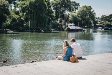 Londra, İngiltere - 1 Ağustos 2018. İki kişi Richmond, Güney-Batı Londra çok sayıda park ve açık alanlar için ünlü bir banliyö kasabasında Thames Nehri nehir üzerinde rahatlatıcı.